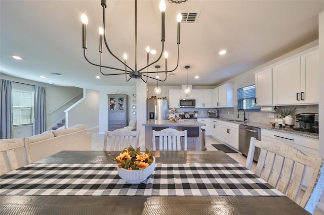 dining area with sink, a notable chandelier, and a wealth of natural light