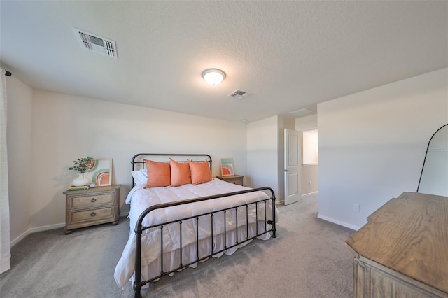 bedroom featuring a textured ceiling and light colored carpet