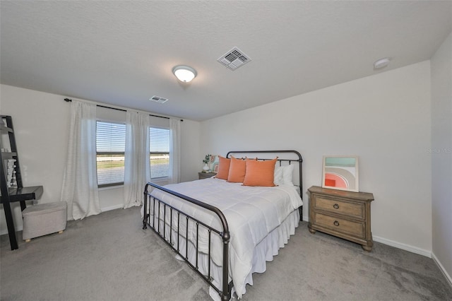 bedroom featuring light carpet and a textured ceiling