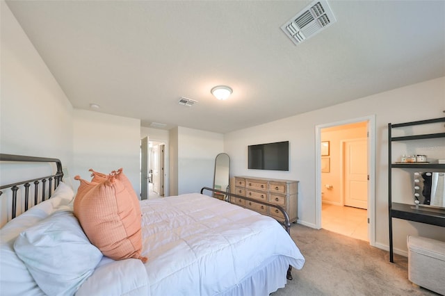 bedroom featuring light carpet and ensuite bathroom