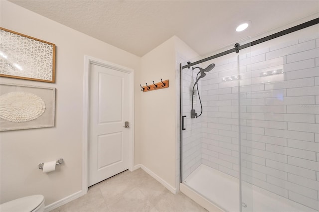 bathroom featuring toilet, tile patterned floors, a textured ceiling, and a shower with shower door