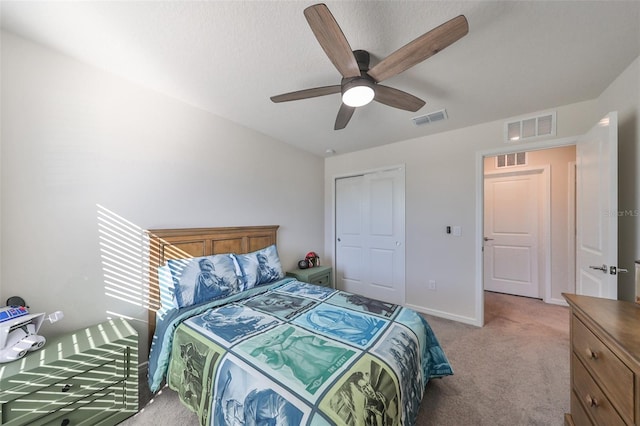 bedroom with a closet, ceiling fan, and light carpet