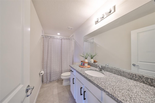 bathroom featuring tile patterned floors, toilet, a shower with shower curtain, vanity, and a textured ceiling