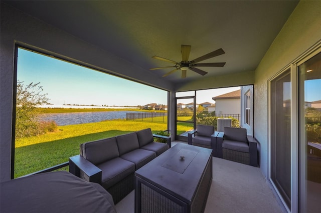 sunroom with plenty of natural light, a water view, and ceiling fan