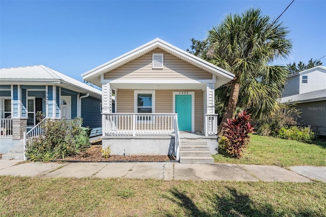 bungalow with a front yard and a porch