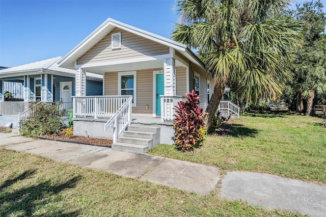 bungalow-style house featuring a front lawn and covered porch