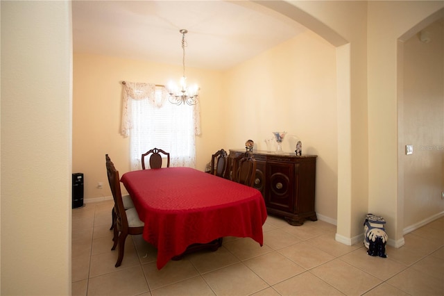 tiled dining room featuring an inviting chandelier