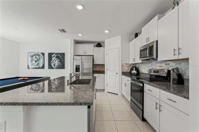 kitchen featuring white cabinetry, stainless steel appliances, sink, and a center island with sink