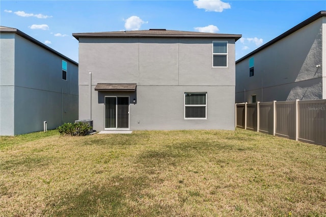 back of property featuring a yard and central air condition unit