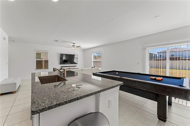 kitchen with a kitchen island with sink, sink, light tile patterned floors, and ceiling fan