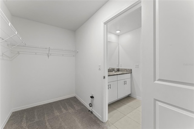 spacious closet featuring indoor wet bar and light colored carpet