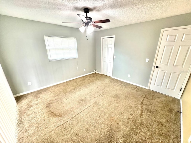 unfurnished bedroom with carpet, a textured ceiling, and ceiling fan