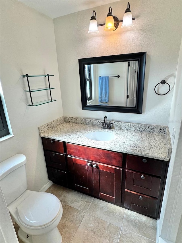 bathroom featuring tile patterned floors, vanity, and toilet