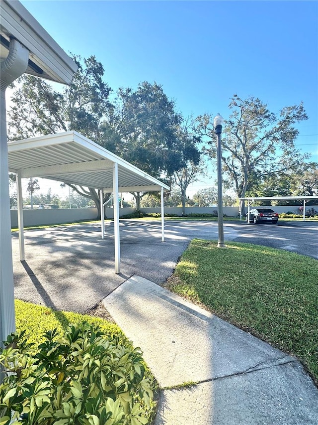 view of parking with a carport and a yard