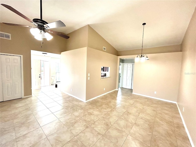 spare room featuring lofted ceiling and ceiling fan with notable chandelier