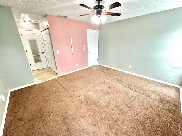 unfurnished bedroom with ceiling fan, light colored carpet, and a textured ceiling