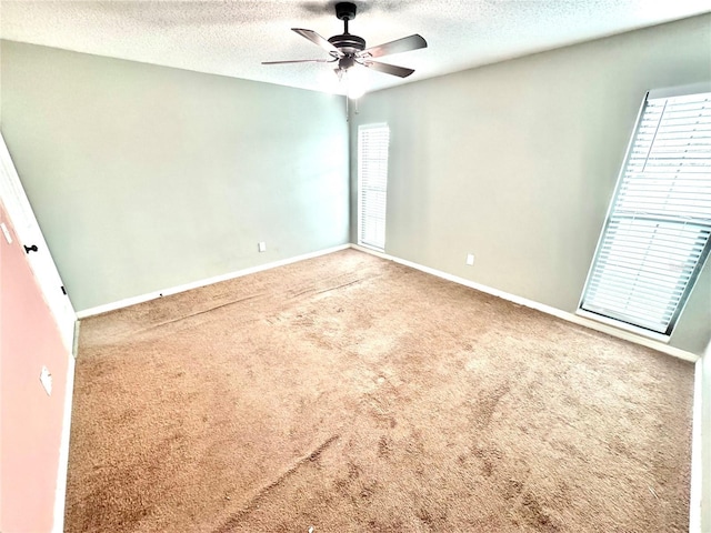 unfurnished room with ceiling fan, carpet floors, and a textured ceiling