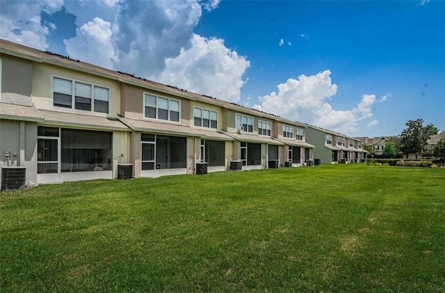 back of property featuring a lawn and central AC unit