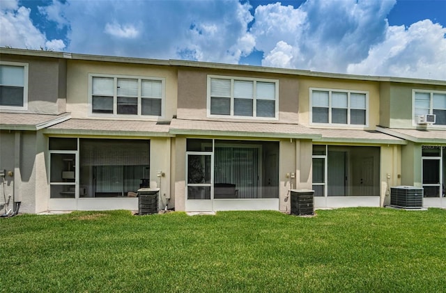 rear view of property with cooling unit and a yard