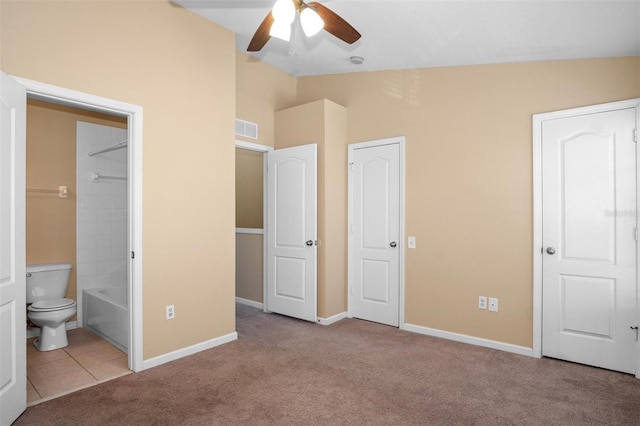 unfurnished bedroom with ceiling fan, lofted ceiling, light carpet, and ensuite bath