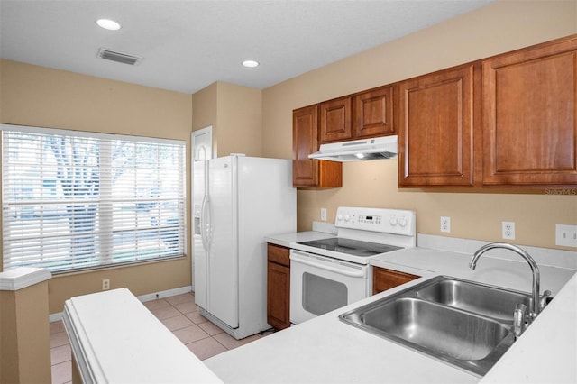 kitchen with light tile patterned flooring, white appliances, and sink