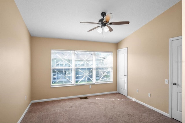 carpeted spare room featuring ceiling fan and lofted ceiling