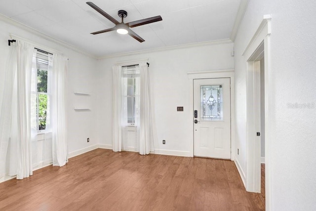 foyer entrance featuring ceiling fan, crown molding, and light wood-type flooring