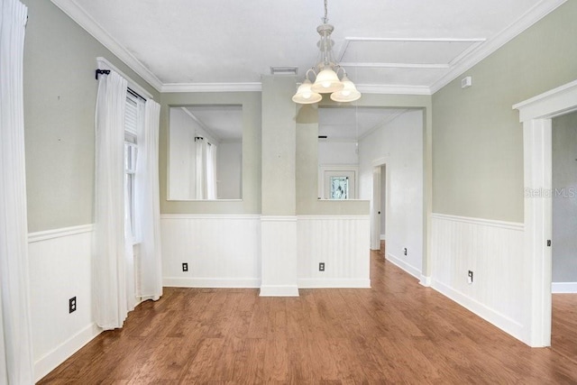 unfurnished dining area featuring ornamental molding, hardwood / wood-style floors, and a chandelier