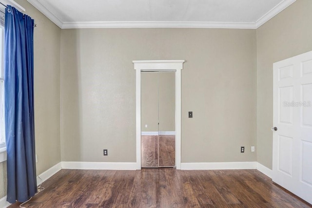 empty room with crown molding and dark hardwood / wood-style flooring