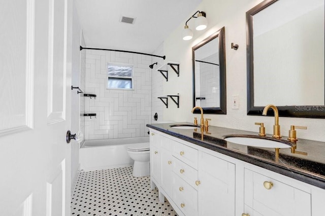 full bathroom with toilet, tiled shower / bath, and vanity