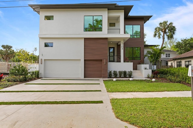 modern home with a balcony, a front lawn, and a garage