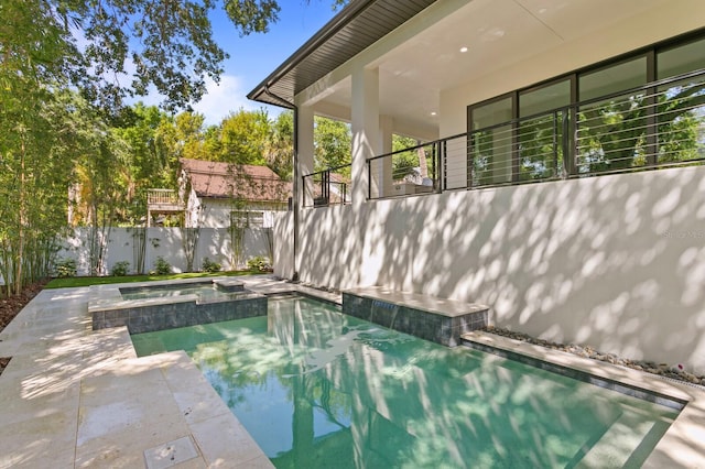 view of swimming pool with an in ground hot tub