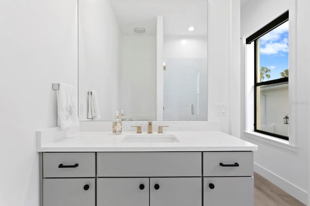 bathroom with vanity, walk in shower, and hardwood / wood-style floors