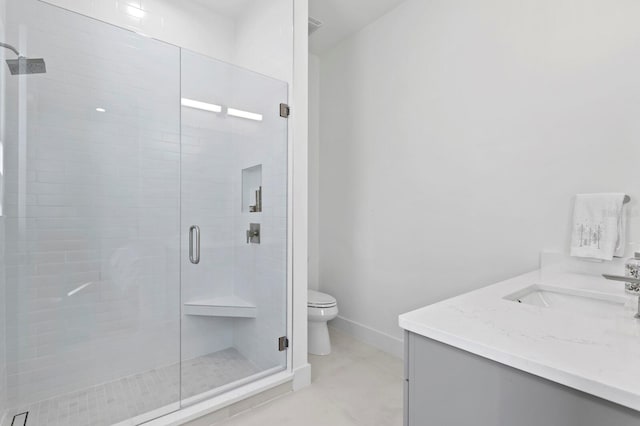 bathroom with a shower with door, vanity, and toilet