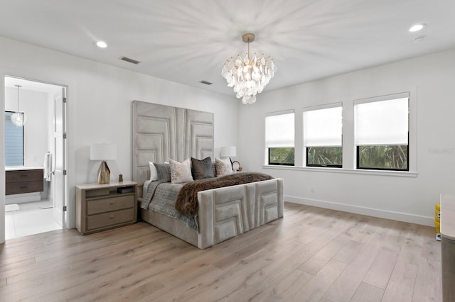 bedroom with an inviting chandelier, connected bathroom, and light hardwood / wood-style floors