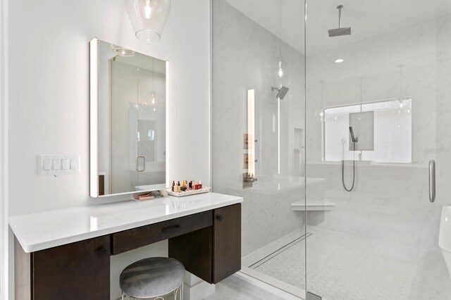 bathroom featuring a shower with door and vanity