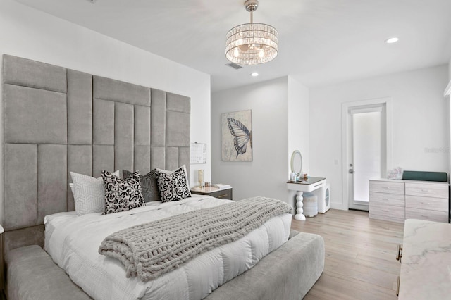 bedroom featuring a notable chandelier and light wood-type flooring