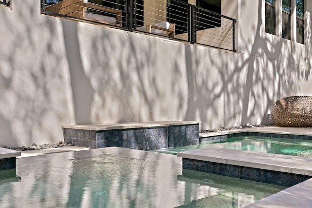 view of swimming pool with an in ground hot tub