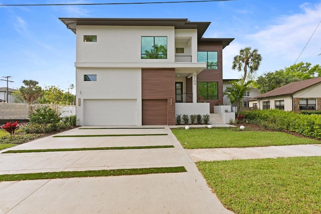 contemporary home featuring a balcony, a front lawn, and a garage