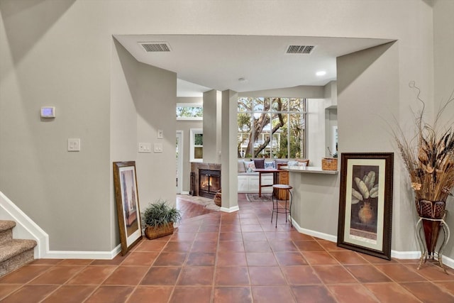 foyer entrance with vaulted ceiling and dark tile patterned flooring