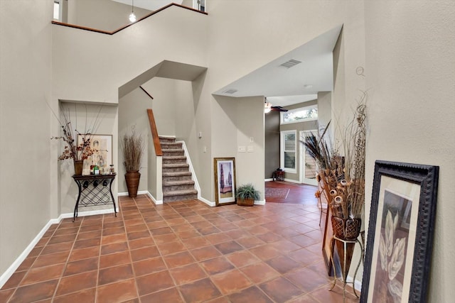 tiled entryway with a towering ceiling