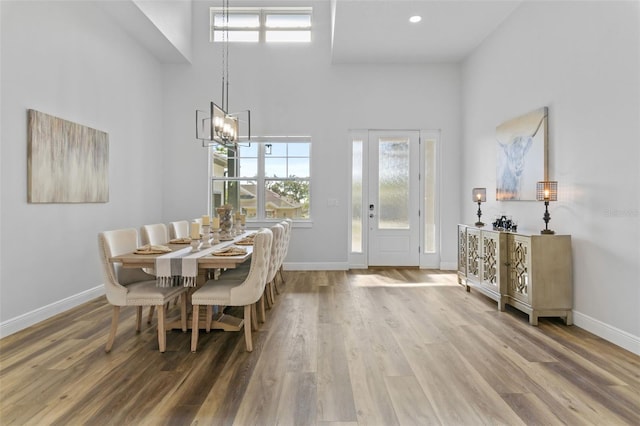 dining area featuring hardwood / wood-style flooring and a high ceiling