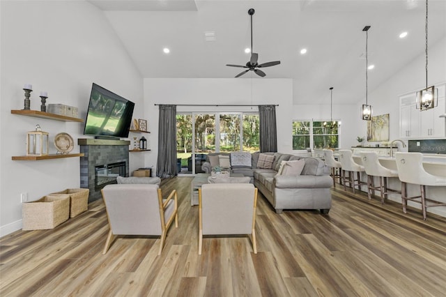 4586 Hickory Oak Dr, Brooksville, FL 34601 - living room featuring high vaulted ceiling, light wood finished floors, a tile fireplace, ceiling fan, and recessed lighting