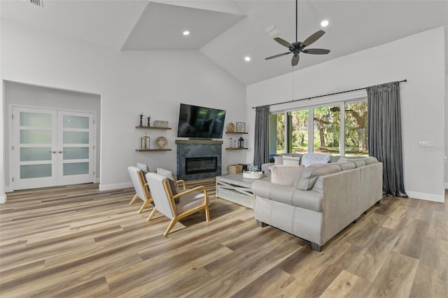 living room with french doors, ceiling fan, high vaulted ceiling, and light wood-type flooring