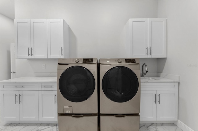 washroom with washer and dryer, sink, and cabinets