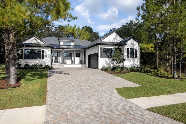 4586 Hickory Oak Dr, Brooksville, FL 34601 - modern farmhouse style home with an attached garage, decorative driveway, stucco siding, a front lawn, and metal roof