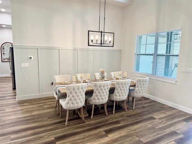 4586 Hickory Oak Dr, Brooksville, FL 34601 - dining area with a decorative wall, wood finished floors, a chandelier, a wainscoted wall, and baseboards