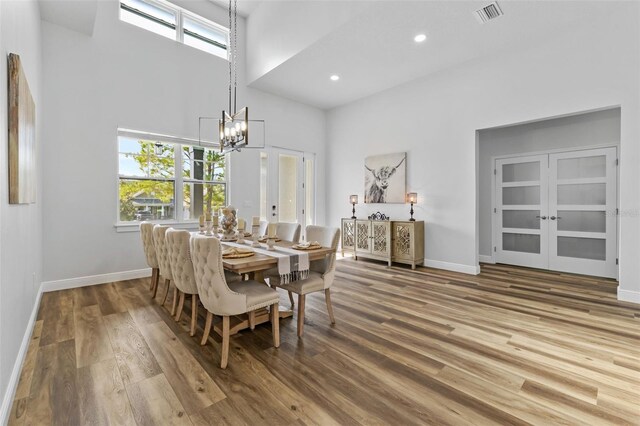 4586 Hickory Oak Dr, Brooksville, FL 34601 - dining space featuring a towering ceiling, a chandelier, wood finished floors, baseboards, and french doors