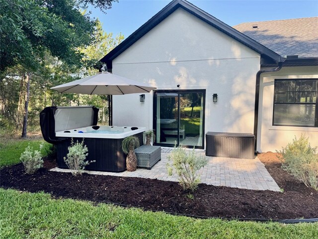 4586 Hickory Oak Dr, Brooksville, FL 34601 - rear view of property with a hot tub, stucco siding, and a patio area