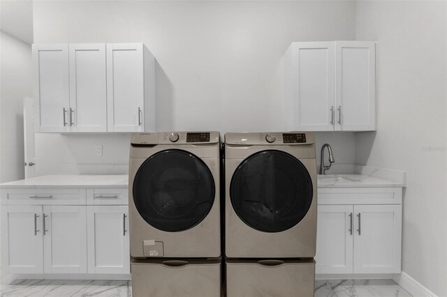 4586 Hickory Oak Dr, Brooksville, FL 34601 - laundry room with light marble finish flooring, independent washer and dryer, cabinet space, and baseboards